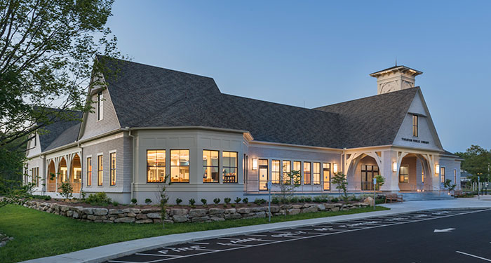 angled photo of the outside of the tiverton public library at night